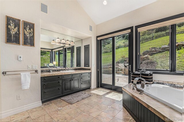12963 Silver Elk Ln, Littleton, CO 80127 - bathroom featuring vanity, baseboards, a bath, and high vaulted ceiling
