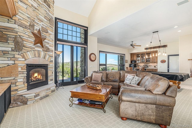 12963 Silver Elk Ln, Littleton, CO 80127 - carpeted living room featuring a stone fireplace, a towering ceiling, a ceiling fan, billiards table, and bar