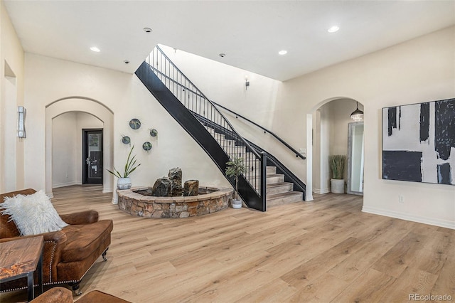 12963 Silver Elk Ln, Littleton, CO 80127 - living room featuring arched walkways, wood finished floors, stairway, recessed lighting, and baseboards