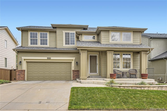 prairie-style home with fence, an attached garage, brick siding, a porch, and concrete driveway