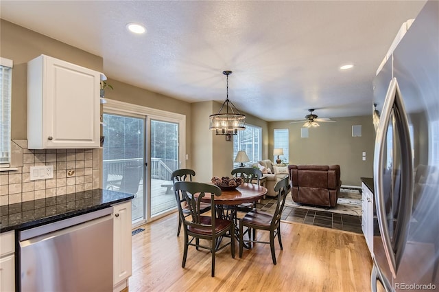 dining space featuring recessed lighting, ceiling fan with notable chandelier, and light wood finished floors