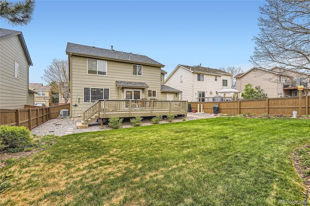 rear view of property featuring a lawn, a deck, a residential view, and a fenced backyard