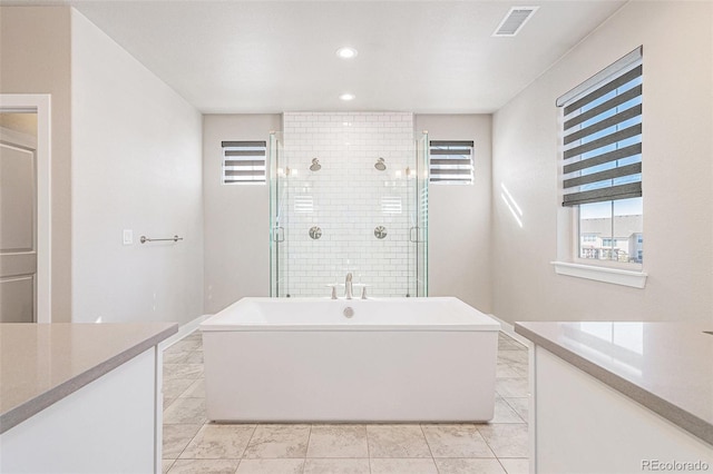 bathroom featuring vanity and independent shower and bath