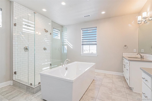 bathroom with vanity and shower with separate bathtub