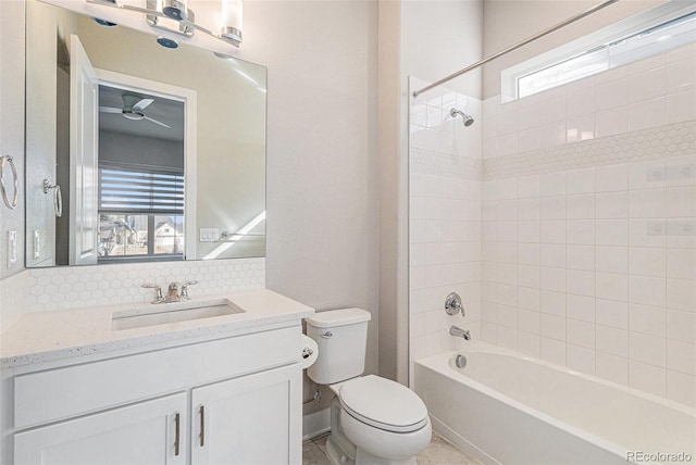 full bathroom featuring tiled shower / bath, vanity, toilet, and backsplash