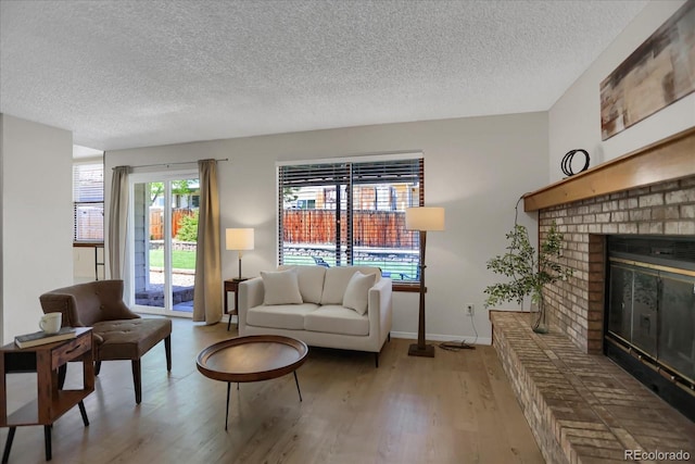 12089 W Burgundy Ave, Littleton, CO 80127 - living room with a textured ceiling, light wood-style flooring, and a fireplace