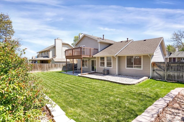 12089 W Burgundy Ave, Littleton, CO 80127 - back of property with a fenced backyard, roof with shingles, a patio, and a wooden deck