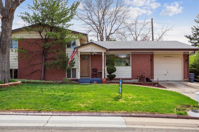 split level home featuring a front lawn, driveway, brick siding, and a garage
