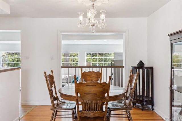 dining room featuring a wealth of natural light, light wood-type flooring, and a chandelier