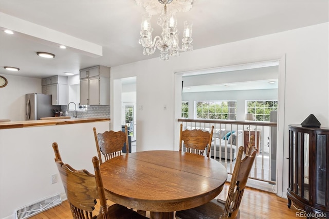 dining room with light wood-type flooring, recessed lighting, a chandelier, and visible vents