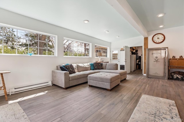 living area featuring recessed lighting, hardwood / wood-style floors, a healthy amount of sunlight, and a baseboard heating unit
