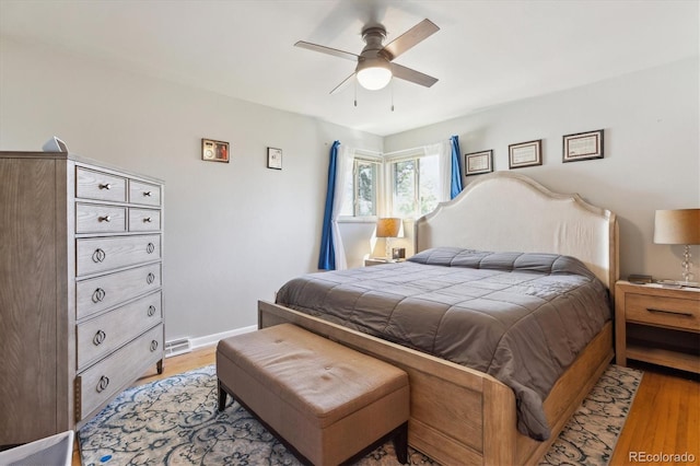 bedroom featuring ceiling fan, baseboards, visible vents, and light wood-style floors
