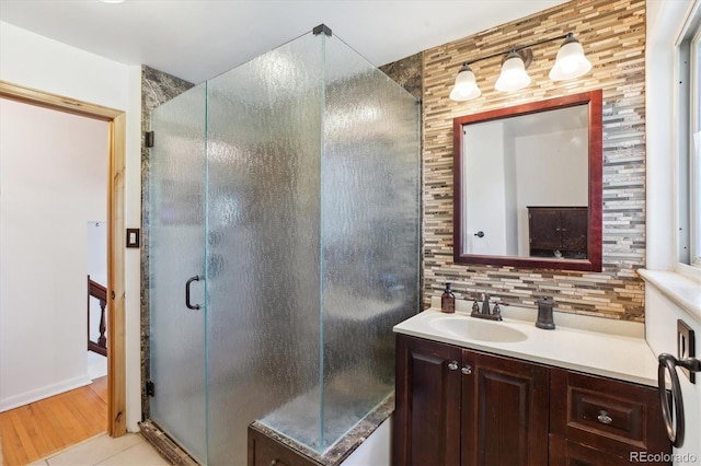 bathroom featuring a shower stall, tile patterned flooring, vanity, and decorative backsplash