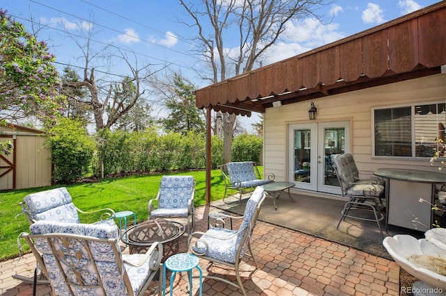 view of patio / terrace featuring an outdoor fire pit, an outbuilding, french doors, and a storage unit
