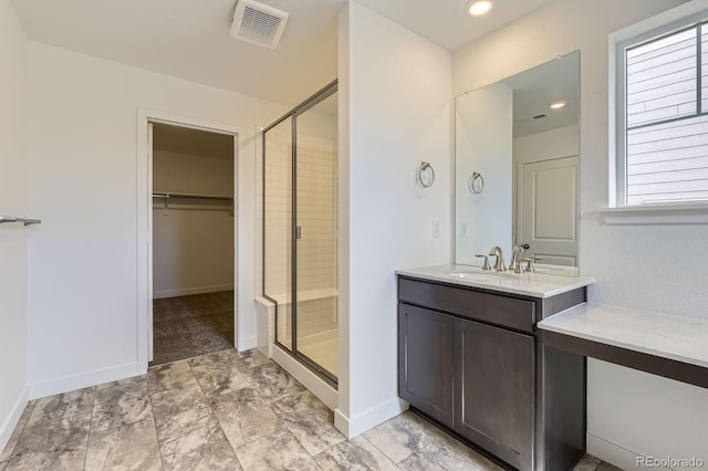 full bathroom featuring visible vents, vanity, a spacious closet, and a shower stall