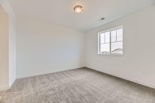 carpeted empty room with baseboards and visible vents