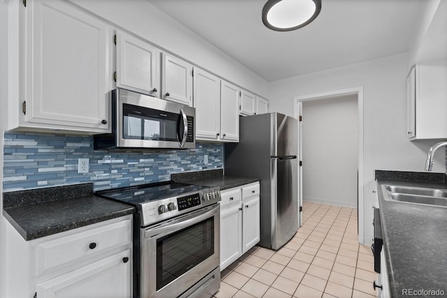 kitchen with white cabinets, sink, tasteful backsplash, light tile patterned flooring, and stainless steel appliances