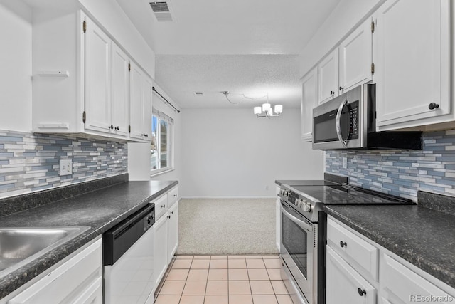 kitchen featuring a textured ceiling, white cabinetry, stainless steel appliances, and light carpet