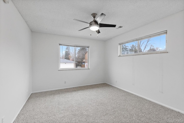 carpeted empty room with a textured ceiling and ceiling fan