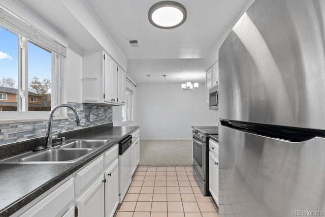 kitchen featuring light carpet, appliances with stainless steel finishes, backsplash, sink, and white cabinets