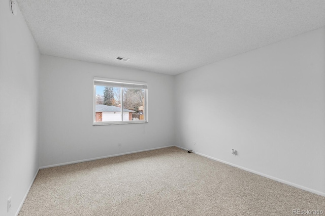 empty room featuring carpet and a textured ceiling