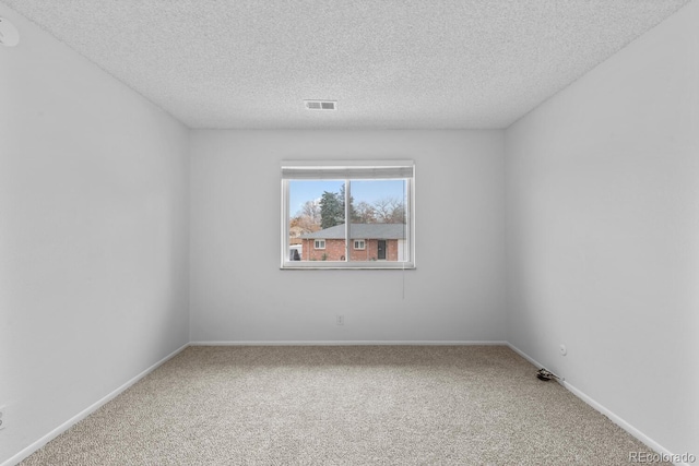 spare room featuring carpet and a textured ceiling