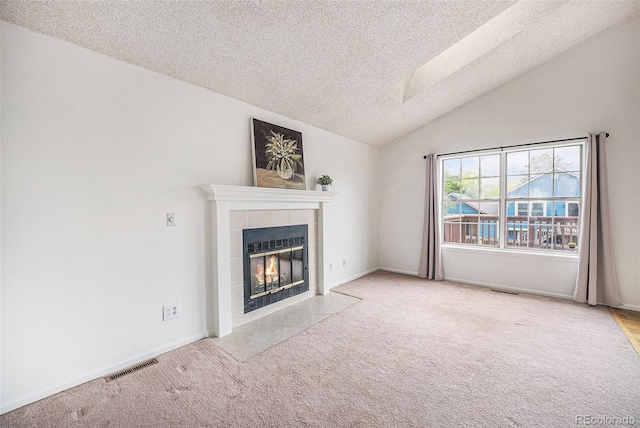 12632 James Ct, Broomfield, CO 80020 - unfurnished living room featuring a textured ceiling, a tile fireplace, carpet flooring, and vaulted ceiling