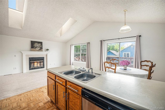 12632 James Ct, Broomfield, CO 80020 - kitchen featuring a skylight, a textured ceiling, a tiled fireplace, lofted ceiling, and open floor plan