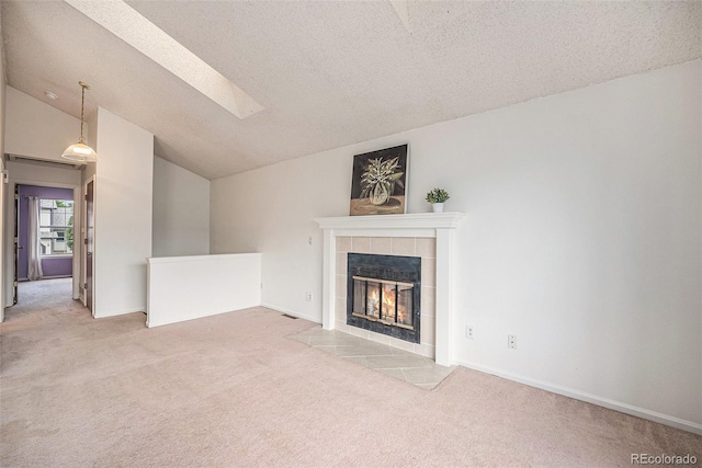 12632 James Ct, Broomfield, CO 80020 - unfurnished living room with carpet floors, a fireplace, a textured ceiling, lofted ceiling, and a skylight