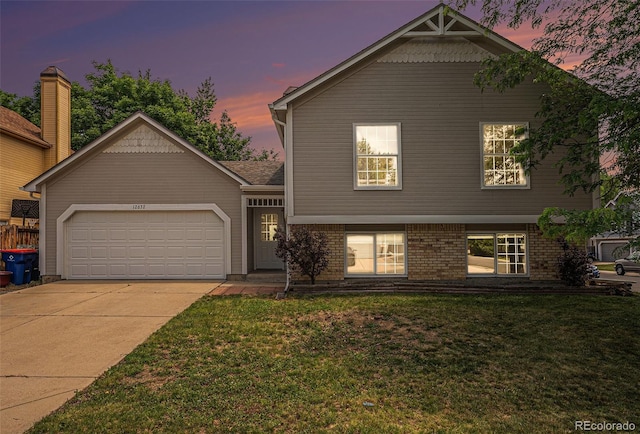 12632 James Ct, Broomfield, CO 80020 - split level home featuring a garage, concrete driveway, a front lawn, and brick siding