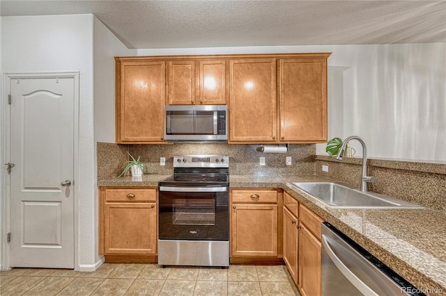 7140 Simms St Unit 102, Arvada, CO 80004 - kitchen with appliances with stainless steel finishes, a sink, tile countertops, light tile patterned floors, and a textured ceiling