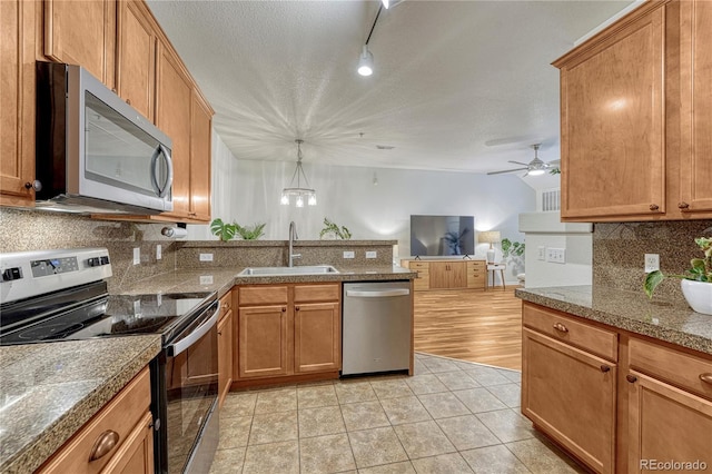 7140 Simms St Unit 102, Arvada, CO 80004 - kitchen with stainless steel appliances, a sink, a peninsula, decorative backsplash, and a ceiling fan