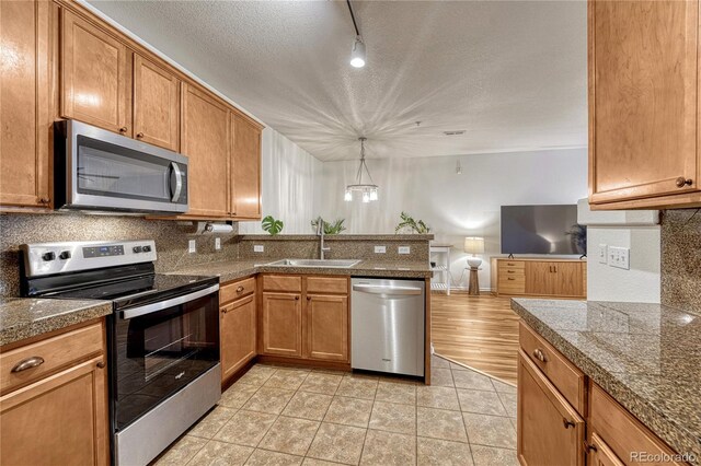 7140 Simms St Unit 102, Arvada, CO 80004 - kitchen with stainless steel appliances, a sink, tile counters, decorative backsplash, and a textured ceiling