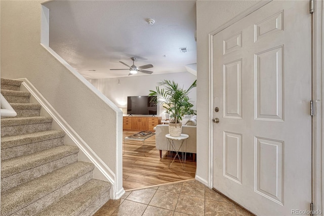 7140 Simms St Unit 102, Arvada, CO 80004 - foyer featuring stairway, light tile patterned floors, ceiling fan, and baseboards