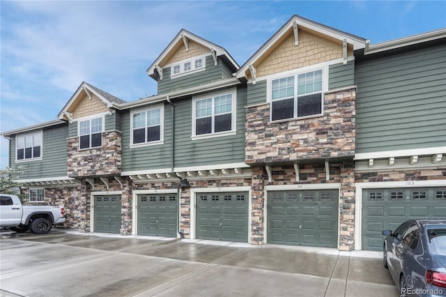 7140 Simms St Unit 102, Arvada, CO 80004 - view of property exterior featuring stone siding, driveway, and a garage