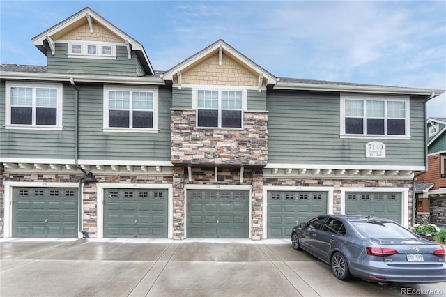 7140 Simms St Unit 102, Arvada, CO 80004 - multi unit property with stone siding, a garage, and driveway