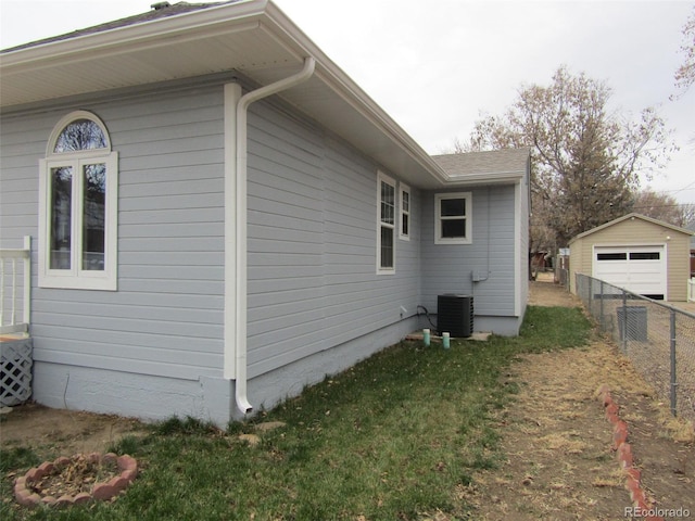 view of side of property with central AC and a lawn