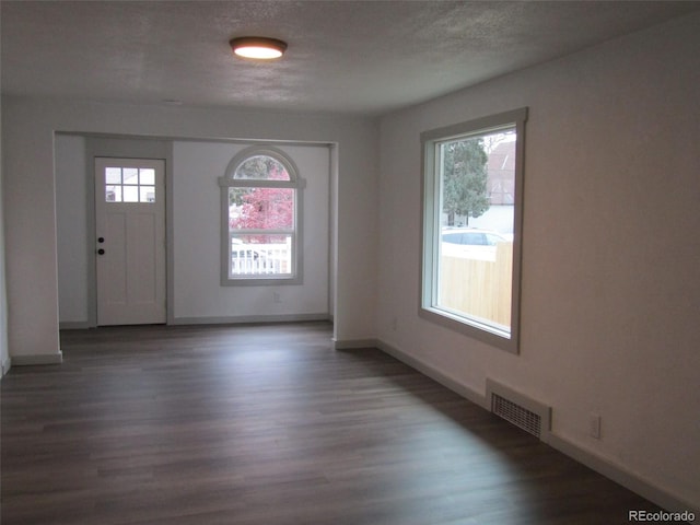 entrance foyer featuring dark wood-type flooring and a textured ceiling