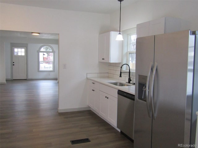 kitchen with sink, white cabinets, pendant lighting, and appliances with stainless steel finishes