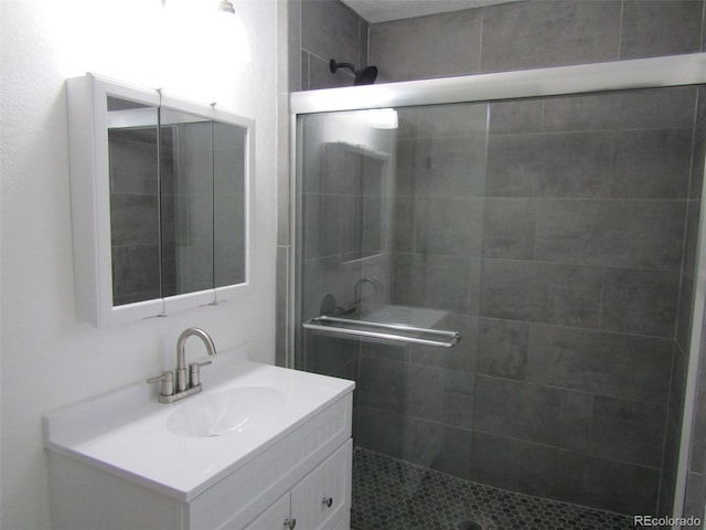 bathroom with vanity and a shower with door