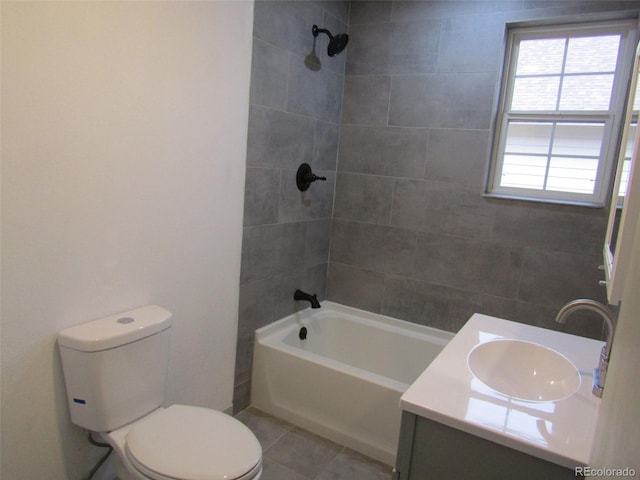 full bathroom featuring tile patterned floors, tiled shower / bath, vanity, and toilet