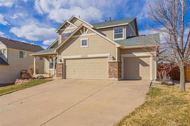 craftsman house featuring brick siding, an attached garage, driveway, and fence