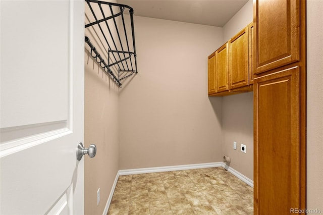 clothes washing area with cabinet space, hookup for an electric dryer, and baseboards