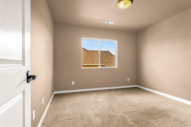 empty room with baseboards, visible vents, and carpet floors