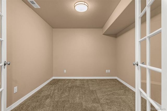 empty room featuring visible vents, carpet flooring, french doors, and baseboards