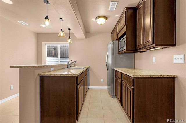 kitchen with dark brown cabinets, visible vents, stainless steel appliances, and a sink