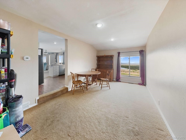 dining area with carpet and vaulted ceiling