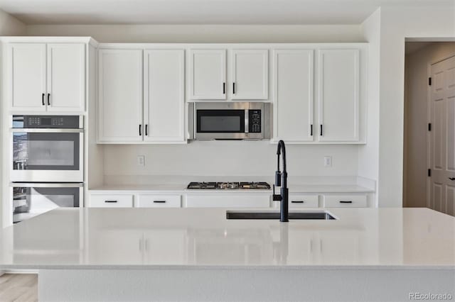 kitchen featuring white cabinetry, sink, and appliances with stainless steel finishes