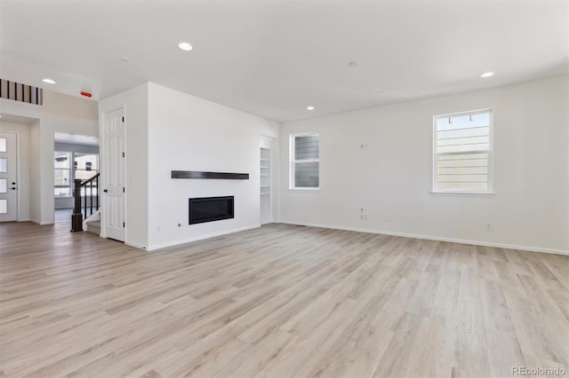 unfurnished living room featuring light hardwood / wood-style flooring and a healthy amount of sunlight