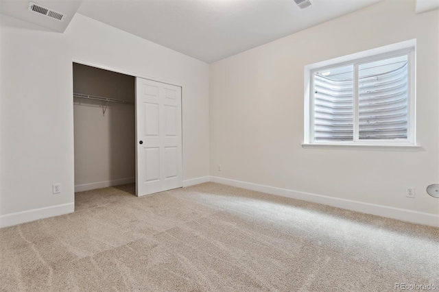 unfurnished bedroom featuring a closet and light colored carpet